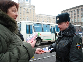 Activist handing out copies of the Russian constitution to police. Source: Kasparov.ru