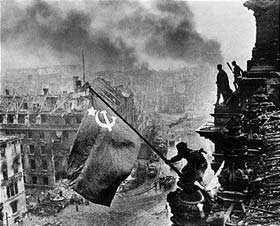 Red army soldiers raising the Soviet flag on the roof of the Reichstag in Berlin