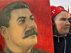 An elderly woman holding a portrait of Stalin. Source: RFE/RL